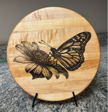 Round wooden plaque with engraved butterfly design
